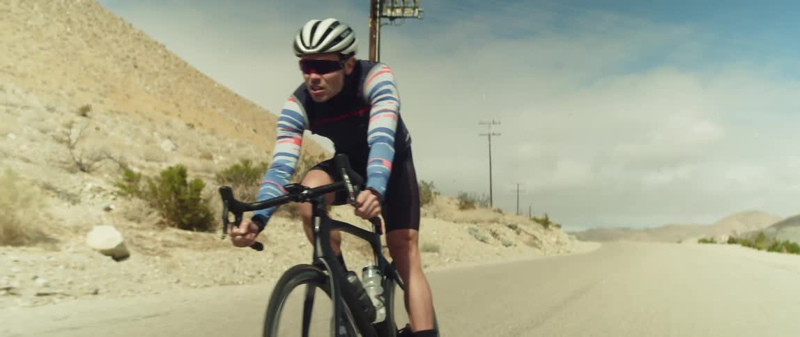 Cyclist riding on road through the desert