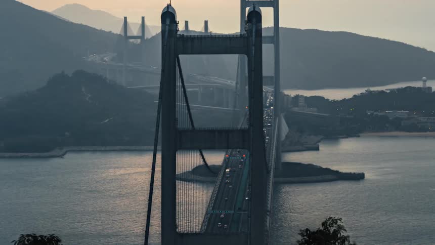 Heavy traffic drives down a bridge over the sea