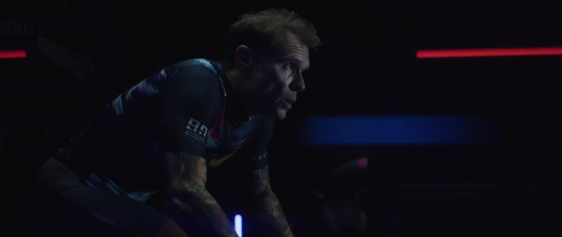 A man is exercising on a machine indoors at night