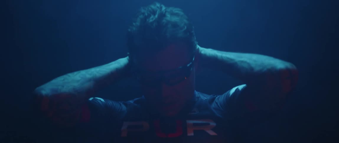 A man is stretching his arms outdoors at night