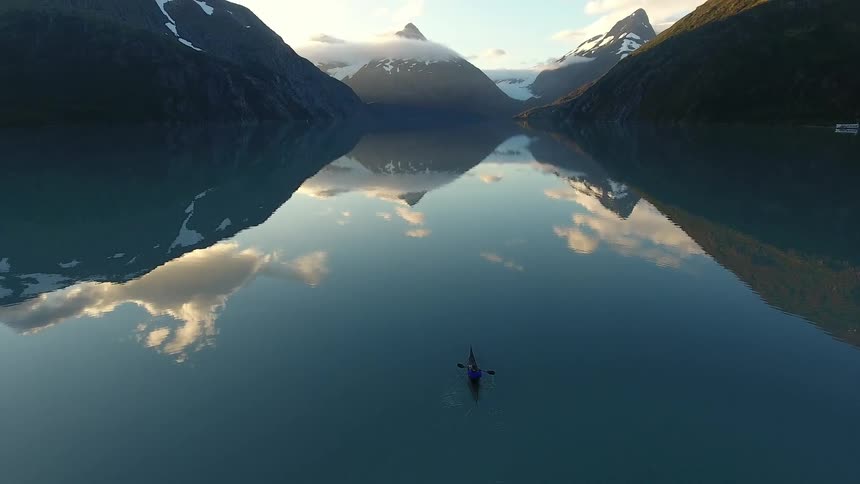 Someone paddling a kayak on a mountain lake