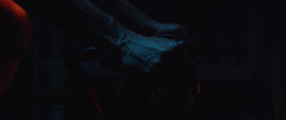 Hands of a man holding tight on a stationary bikes handlebar which he is exercising on