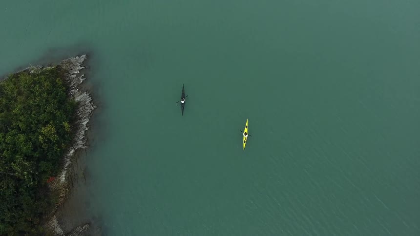 Two kayakers wade through clear water