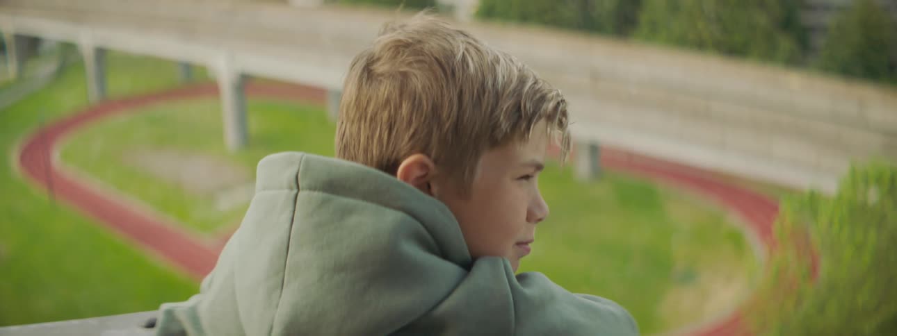 A boy looks over the balcony