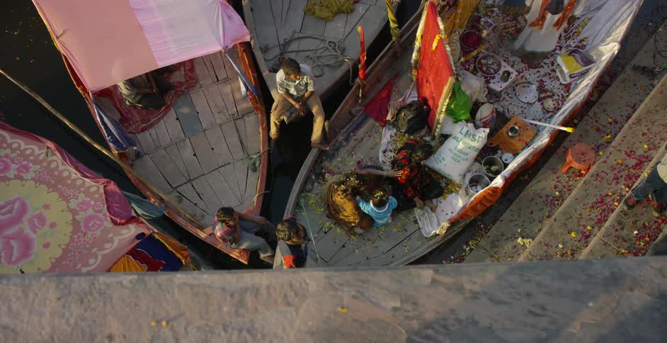 People are sitting below on boats