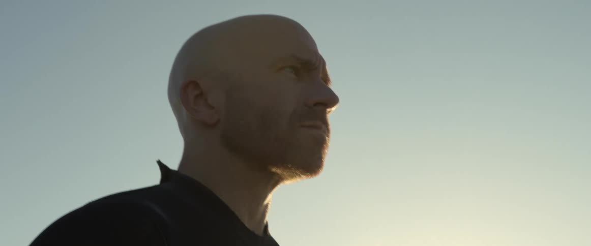 A man looks into the distance while standing outdoors during the day
