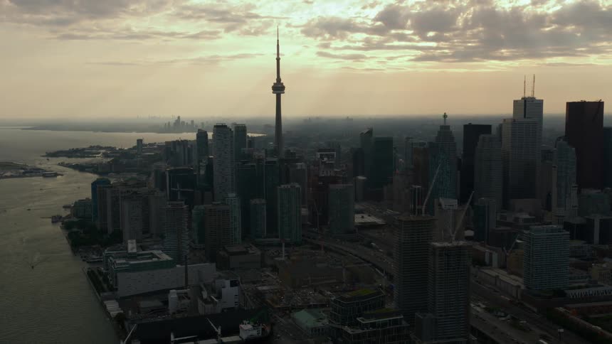 The sun is low in the sky over a city on the river