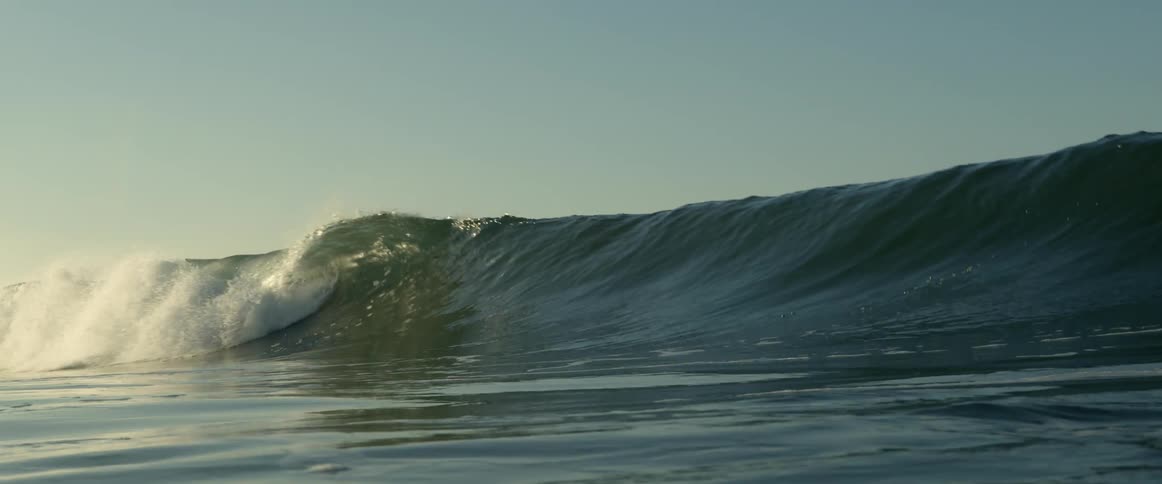 A wave curls and breaks as it comes toward shore