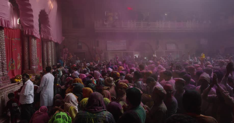 A crowd of people wave and cheer by a temple