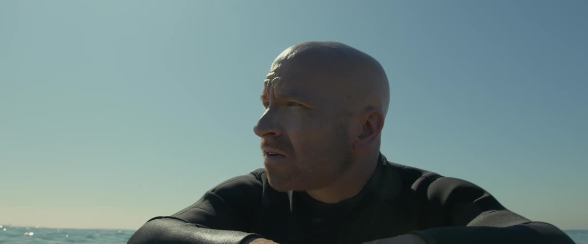 A man is floating on his surfboard