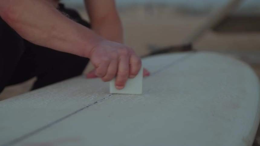 A man setting down a surfboard