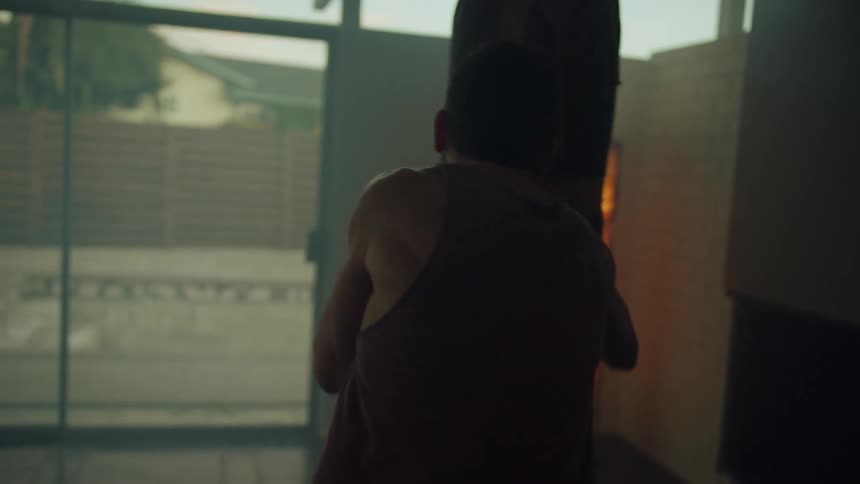 A man is boxing indoors near a window