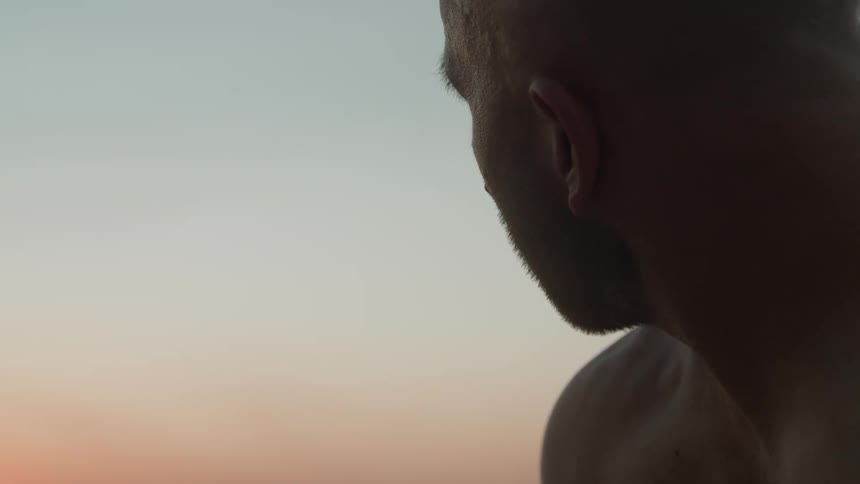 A man sitting outside looking at the sunset