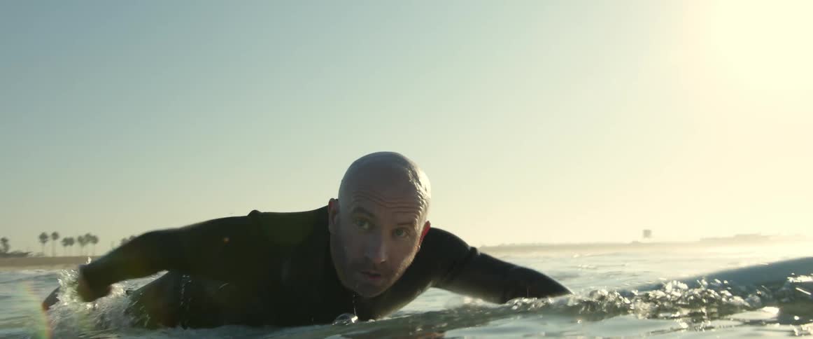 A man on a surfboard paddling out
