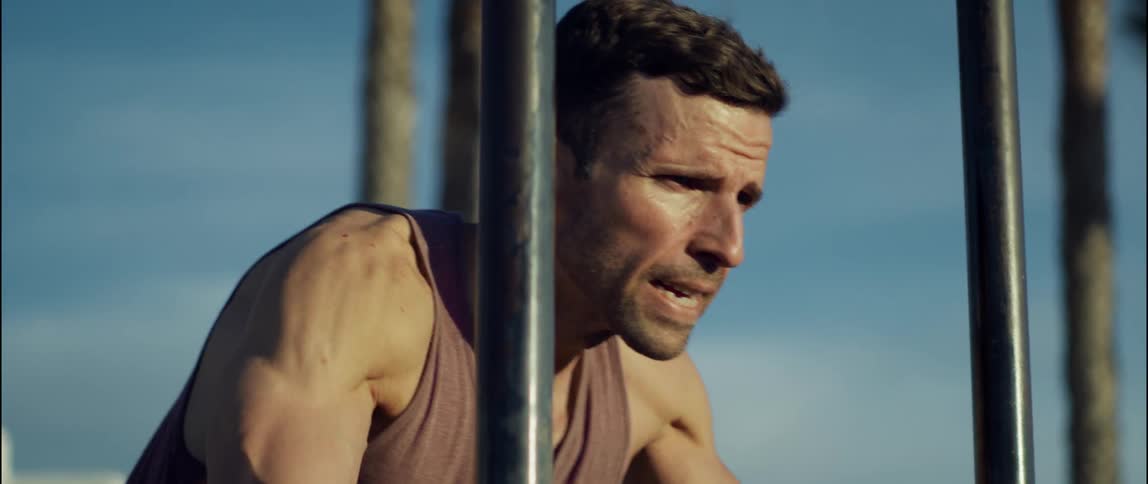 A man does push ups on playground equipment