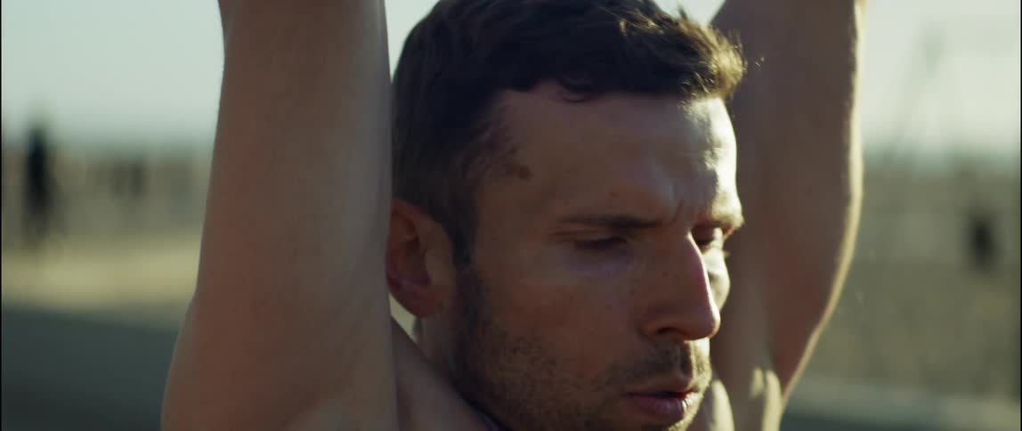 A young man is working out outdoors in the day time