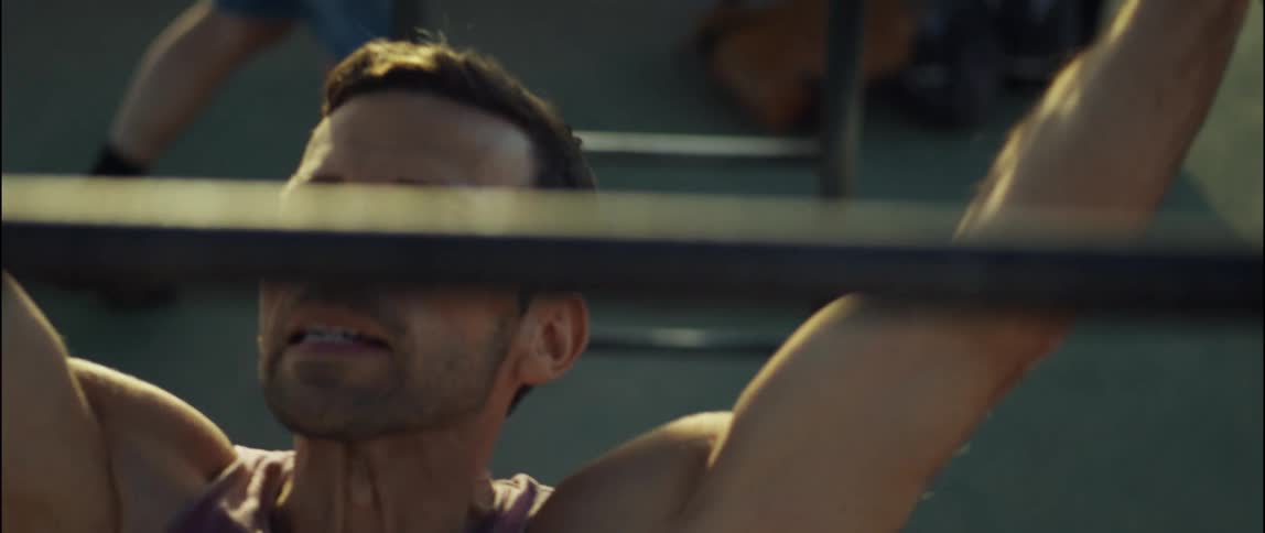 A man pulls himself across monkey bars in a playground