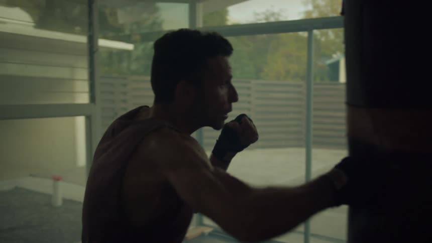 A man at home throws punches at a punching bag