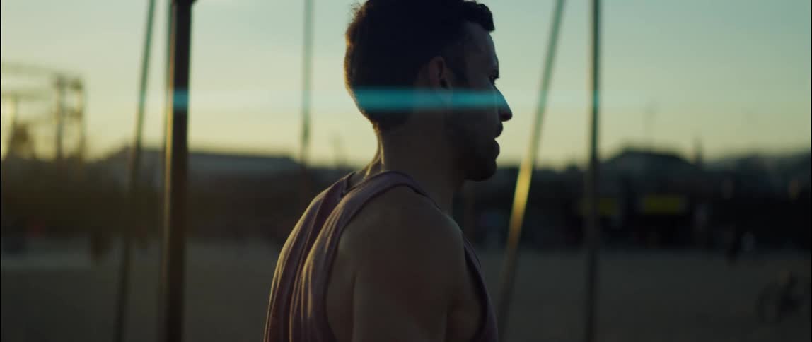 A man is walking in a park near swings