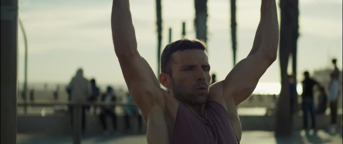 A young man is working out outdoors in the middle of the day