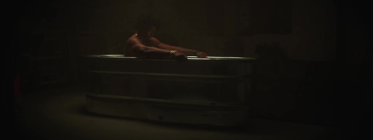 A man is sitting in his bathroom during the night time