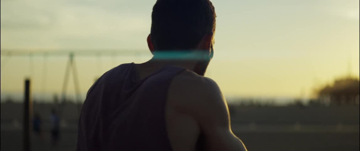 A man is exercising outdoors while the sun is setting