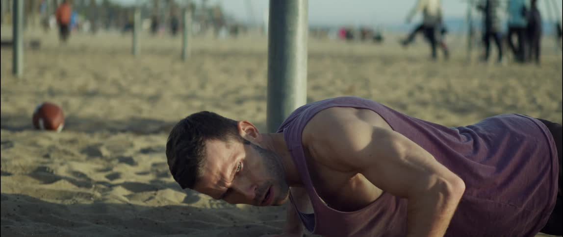 A man is exercising at the beach during the daytime