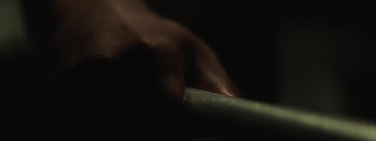 A hand wraps around a metal pole
