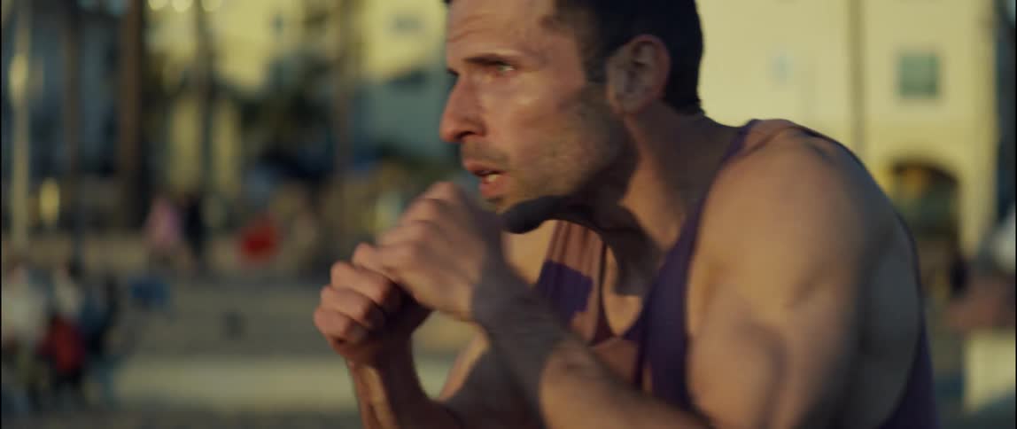 A man in a tank top punching and sparring the air outside