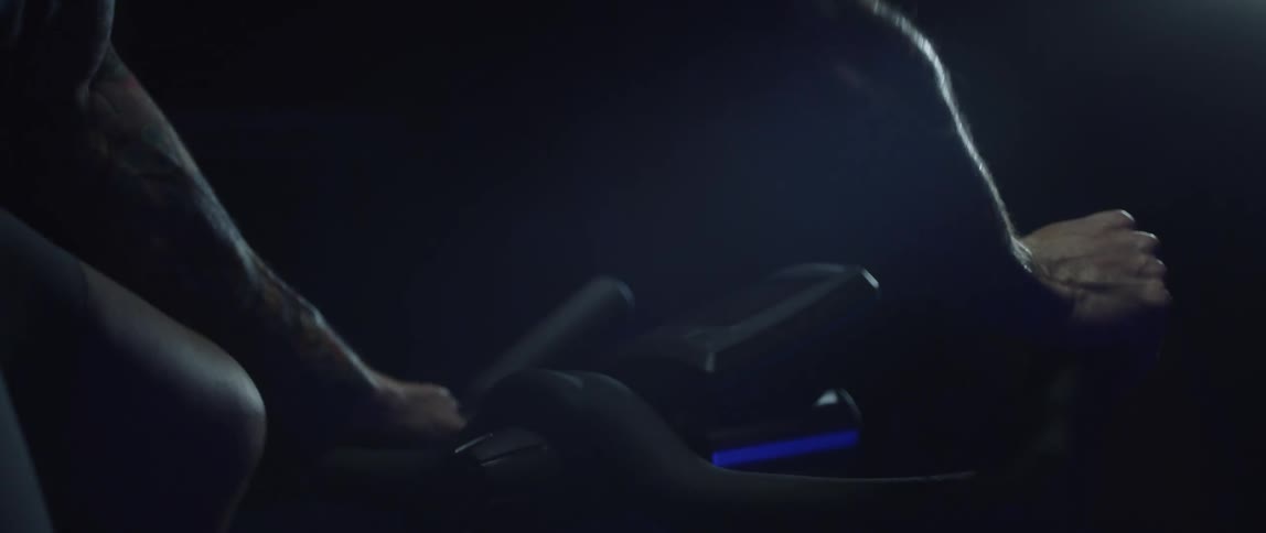 A man riding a stationary bike in a dimly lit room
