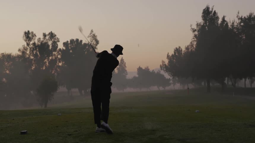 A golfer tees off on a golf course
