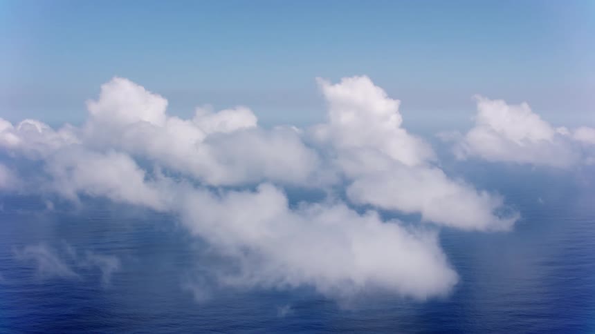 Dense clouds cast shadows on the ocean below