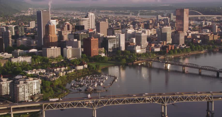 Traffic travels over the bridges across the willamette river with the portland downtown and skyline behind