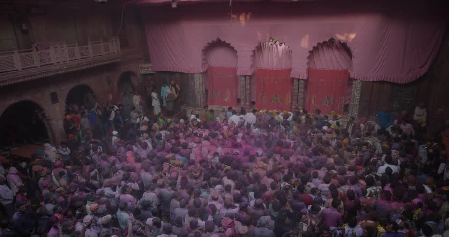 A large crowd of people are gathered inside a building for a festival