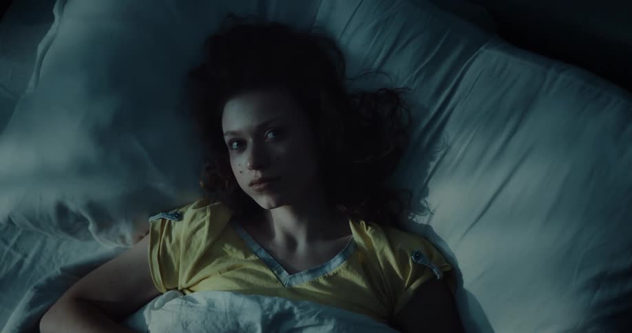 A woman is sleeping in a bed under the covers