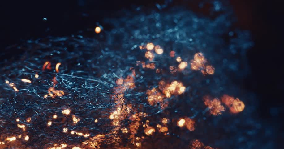 Lights that resemble flames move across debris on the ground