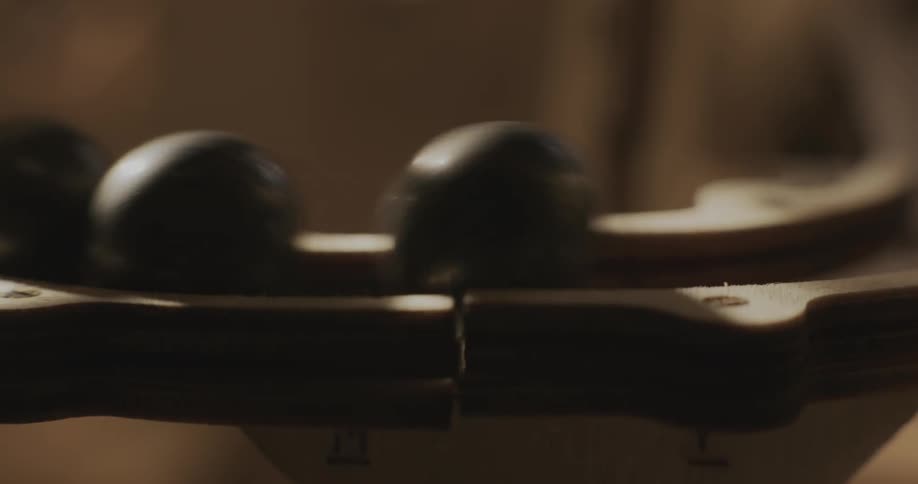 Two marbles roll and crash into another marble on a track