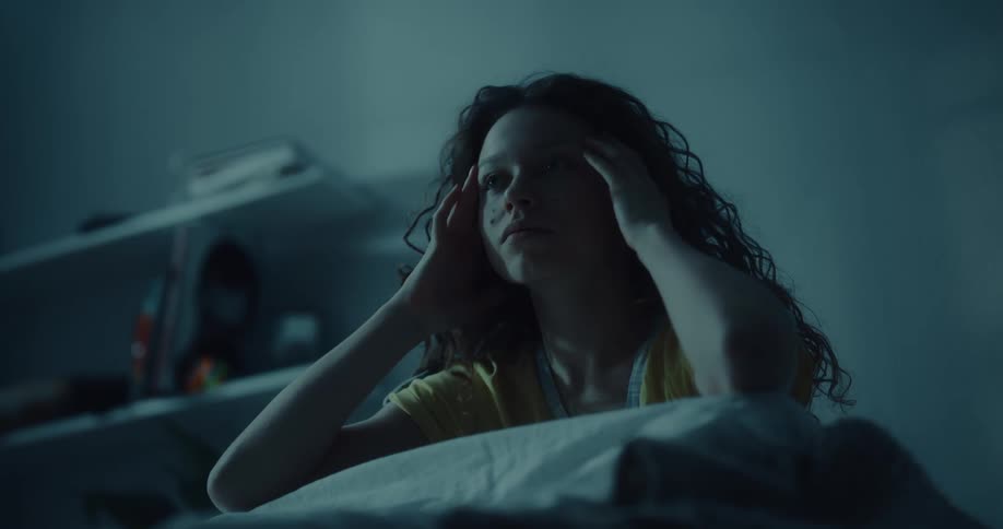 A teenager wakes up and gets out of bed