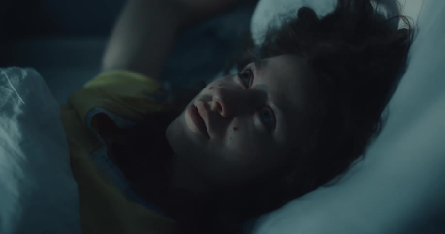 Young woman tossing and turning in her bed trying to sleep at night