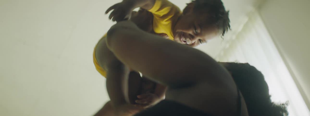 A baby being spun and played with in the air by their mother