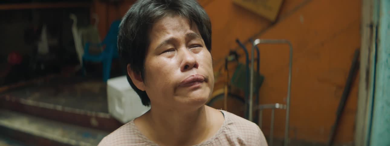 An asian woman crying inside a building