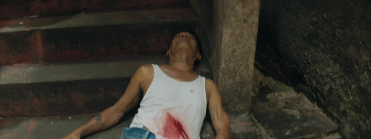 A man laying bleeding on the bottom of a staircase