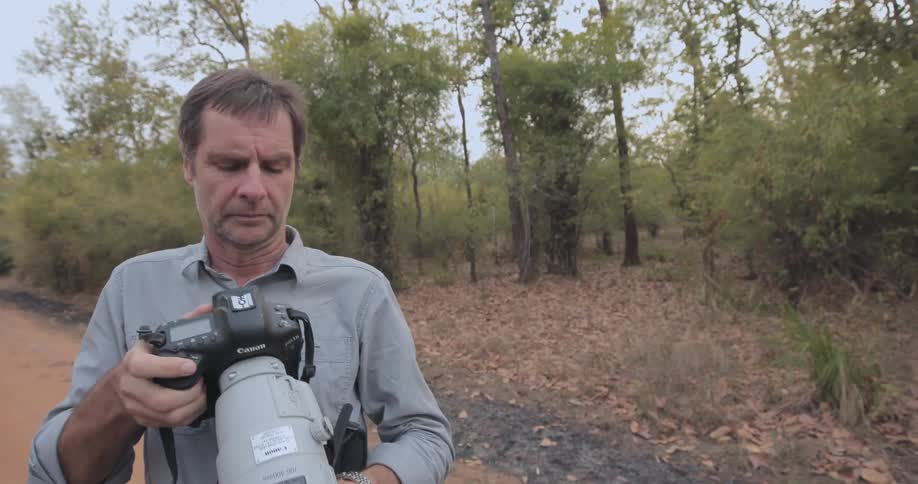 A man is using a camera with a long lens