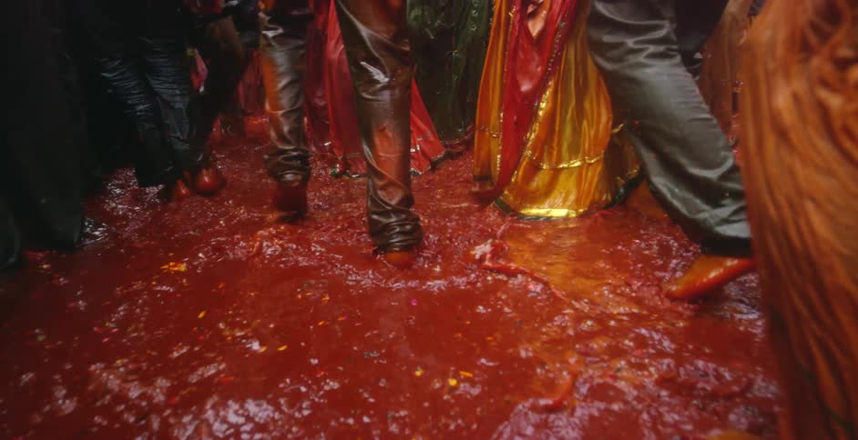 People walk around in a large puddle of colored water