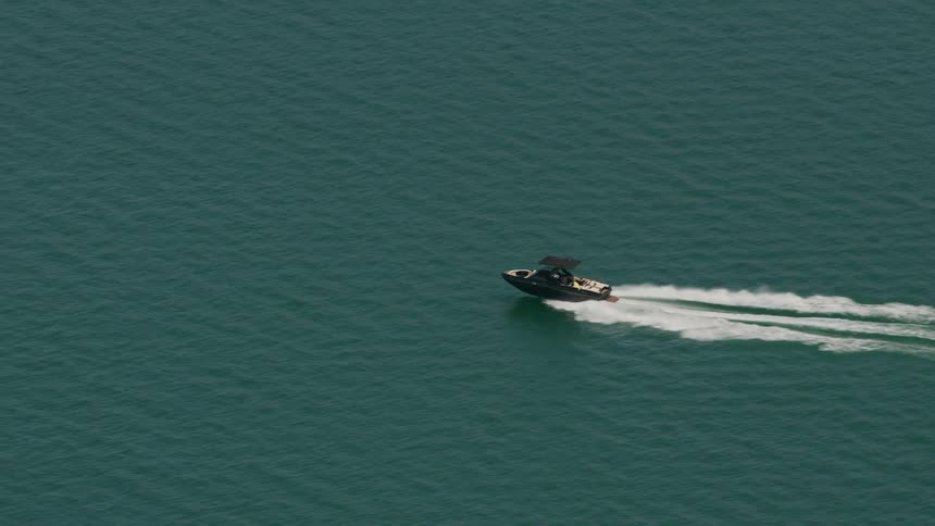 A person drives their boat in the ocean