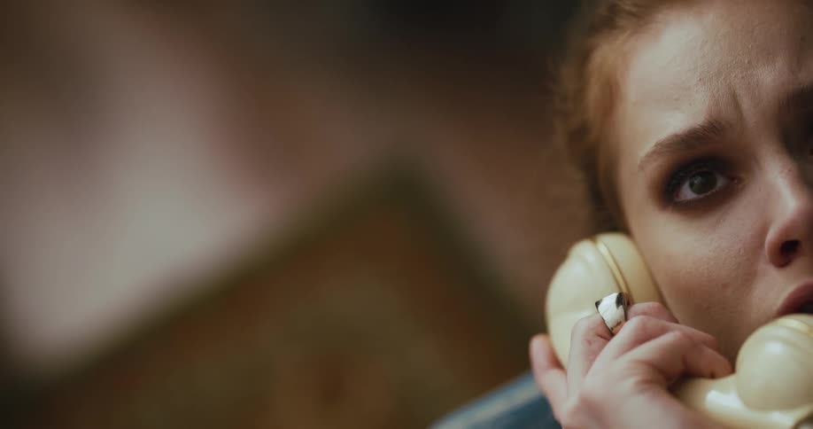 A woman answers a landline phone