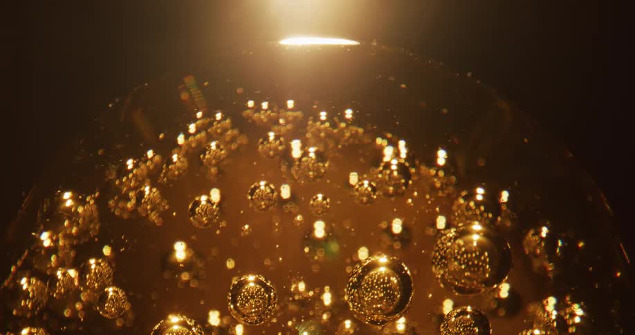 A glass ball with air bubbles rotates and shimmers like gold