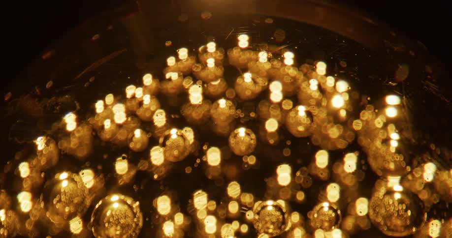 Air bubbles inside a marble glow under a warm light