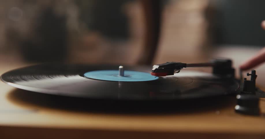 A woman puts a record on a vintage record player