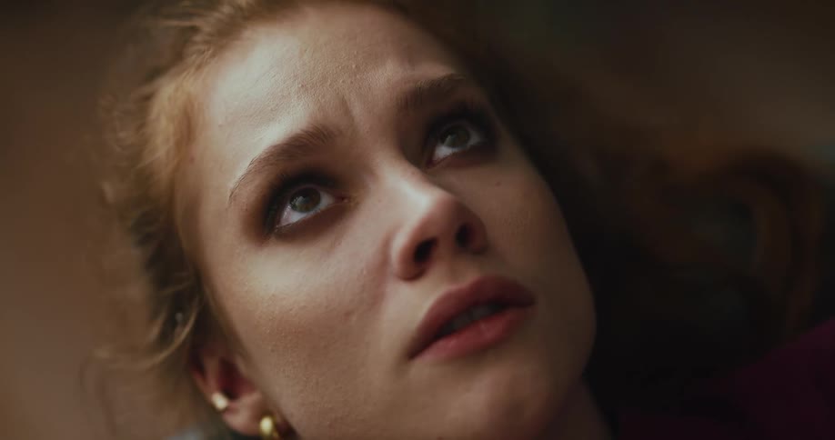 A teenage girl lies on the floor and looks up towards the ceiling